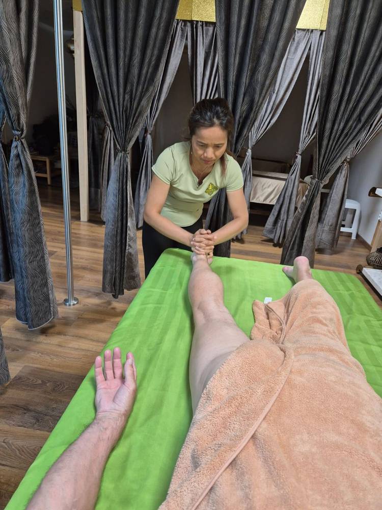 Masseuse giving a Thai leg massage