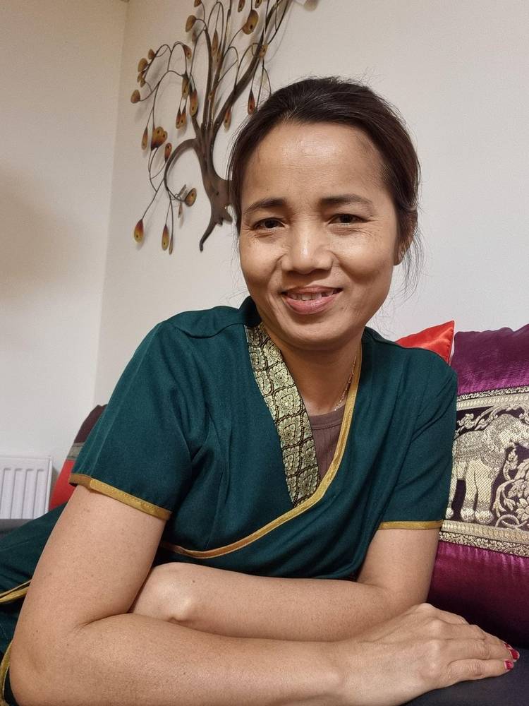 Masseuse Thiwa in traditional Thai dress